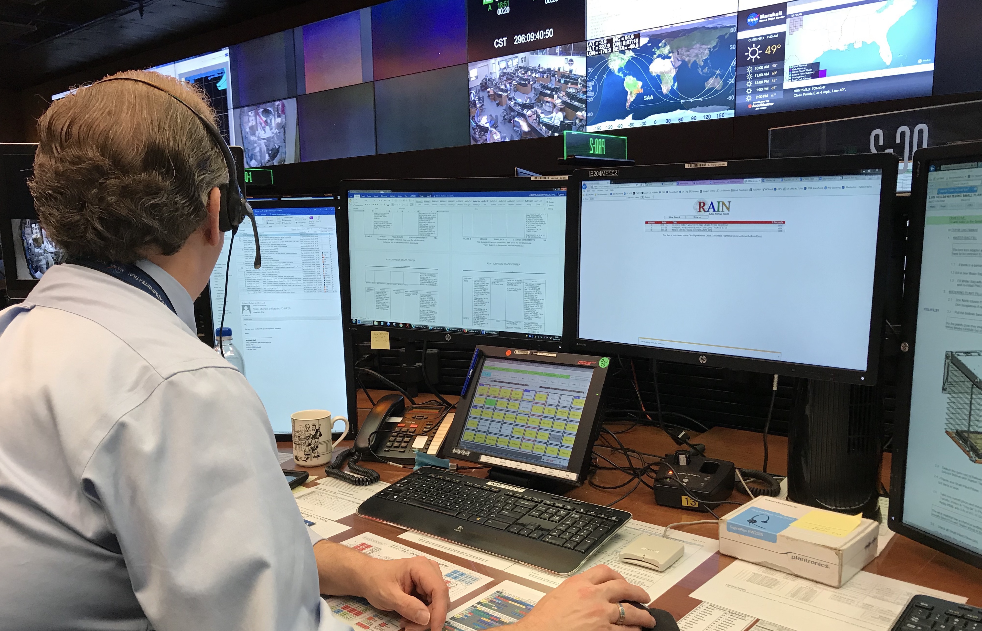 A person sitting at a computer in Mission Control